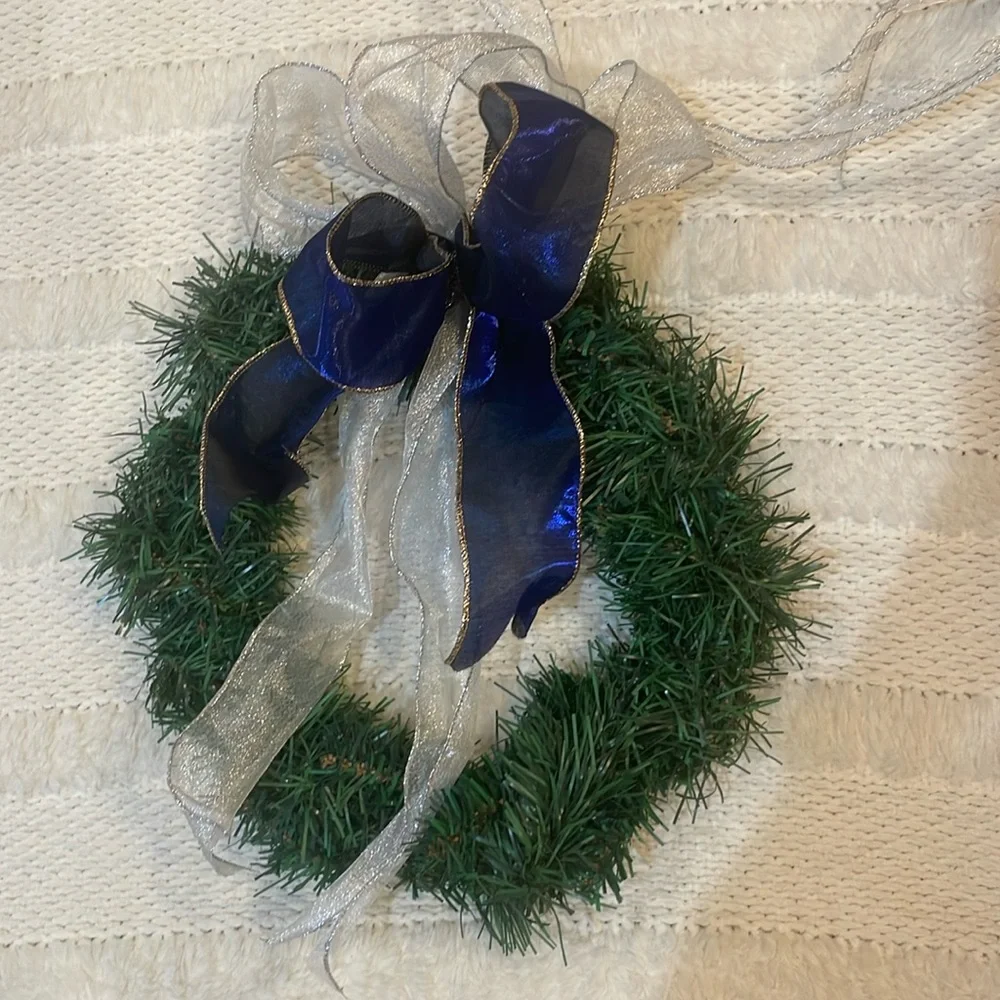 Green Christmas holiday wreath with blue and silver ribbon